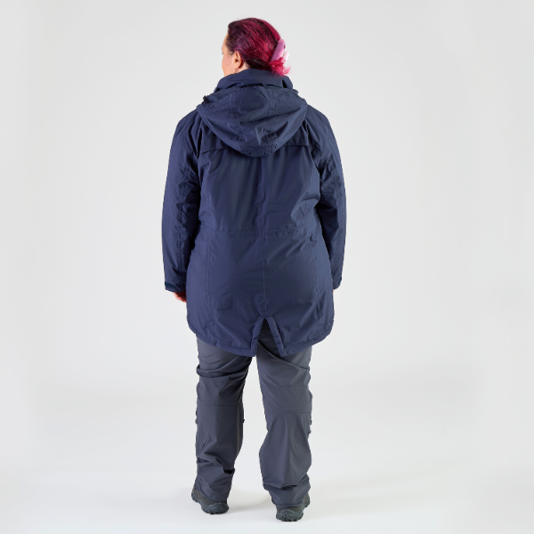Person wearing a navy blue winter coat and pants on a white background