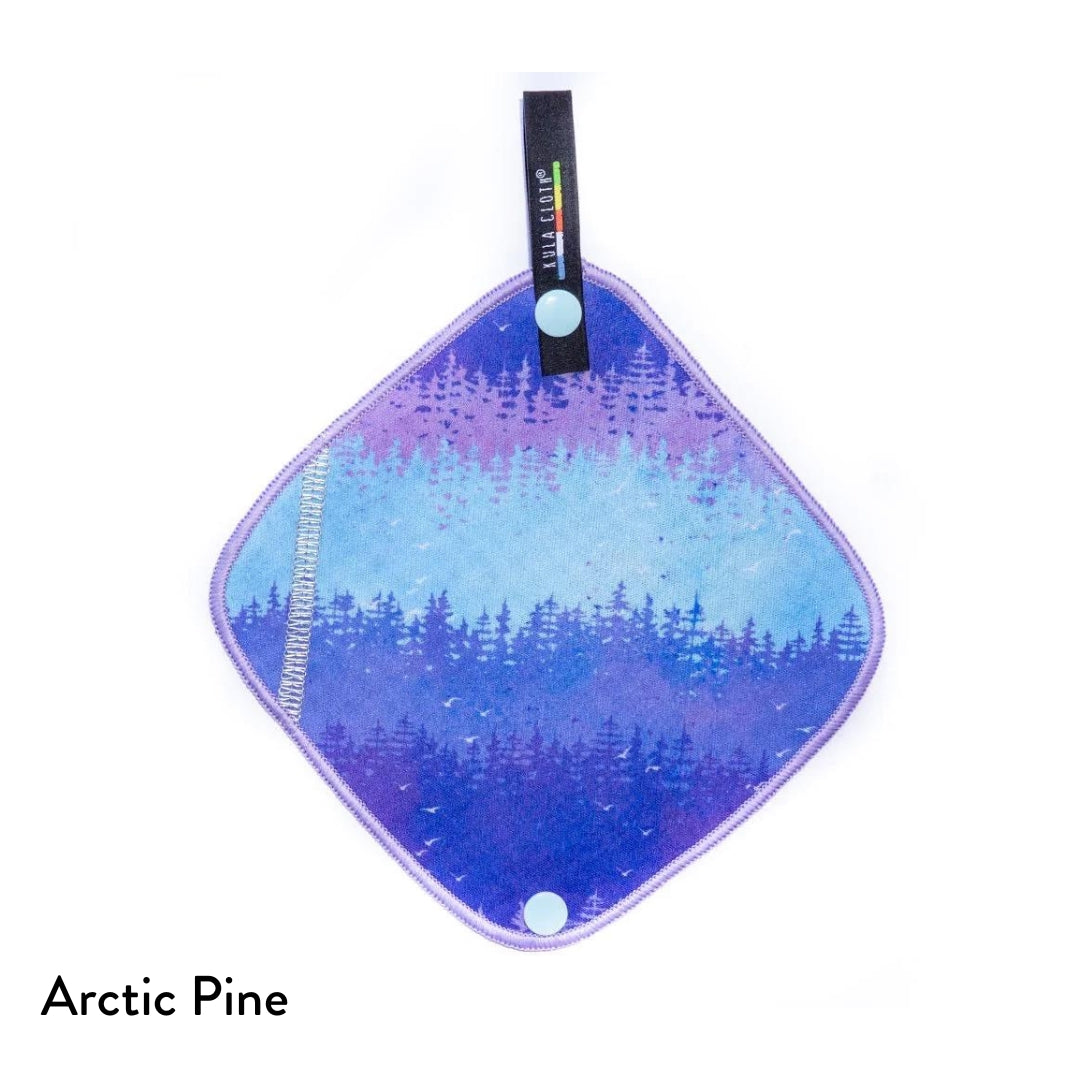 kula cloth pee cloth featuring bands of tree lines, in colours from blue through to light blue and light purple, with a lilac trim